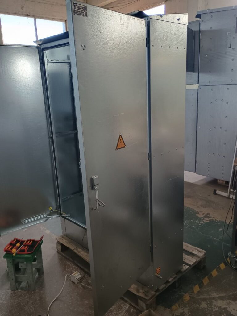Оцинкованный корпус напольного шкафа НКУ с открытой дверью на сборке в цеху ЛК Энергия